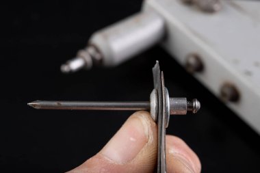 İki metal levha sürükleyici. Çeliği perçinlerle bağlamak. Koyu arkaplan.