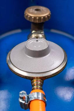 Gaz tüpü, indirgeyici. Gaz tesisatı aksesuarları. Koyu arkaplan.