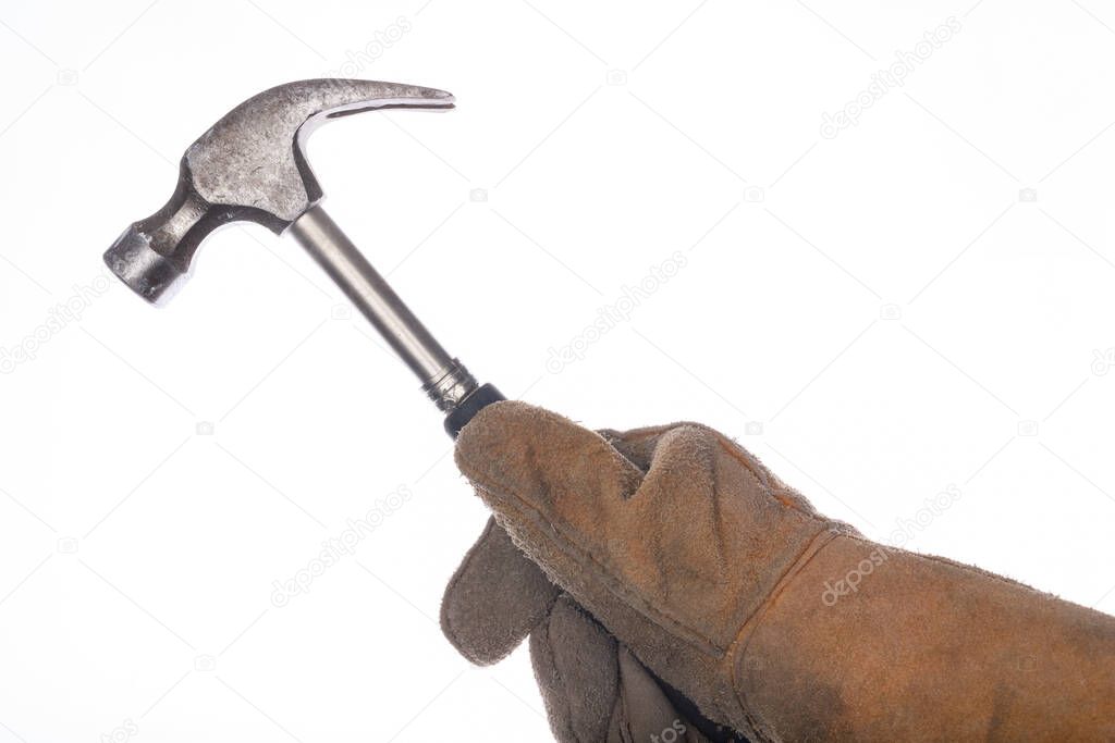 A steel hammer held in the hand. Accessories for locksmiths and welders. Light background.