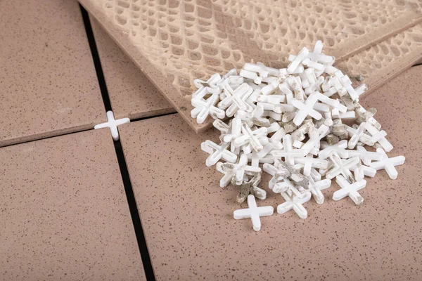 White plastic crosses used for tiling. The process of laying glaze in industry. Light background. — Stock Image White Plastic Crosses Used Tiling Process Laying Glaze Industry Light Stock Image