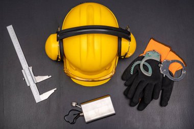 İnşaat miğferi, kelepçeler ve şişede votka. Sorumlu mühendis pozisyonunda sarhoşluk. Koyu arkaplan.