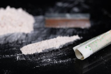 Uyuşturucu ve para bardağa saçılmış. Suç mahallinde yasadışı uyuşturucu. Koyu arkaplan.