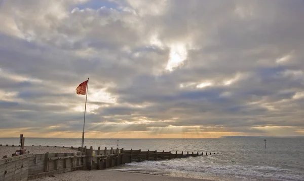 Cena pôr do sol com raios de sol sobre o mar liso — Fotografia de Stock