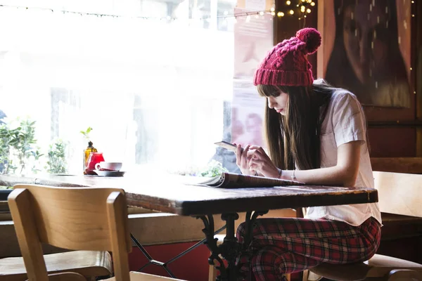 Mujer sentada en la mesa y usando smartphone — Foto de Stock