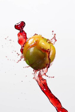 Yeşil elma ve splash beyaz arka planda kırmızı suyu