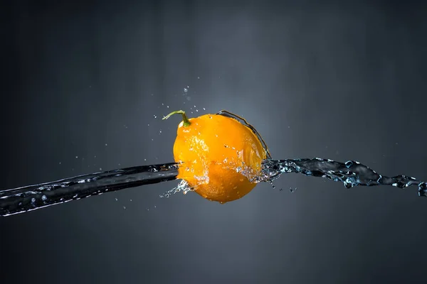 Limón y salpicadura de agua sobre fondo gris —  Fotos de Stock