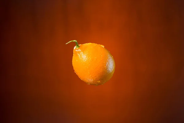 Limón y salpicadura de agua sobre fondo naranja —  Fotos de Stock