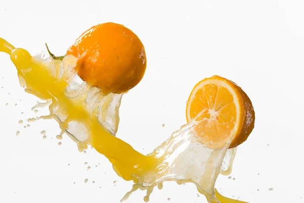 Due metà di limone e spruzzi di succo isolati su dorso bianco — Foto Stock