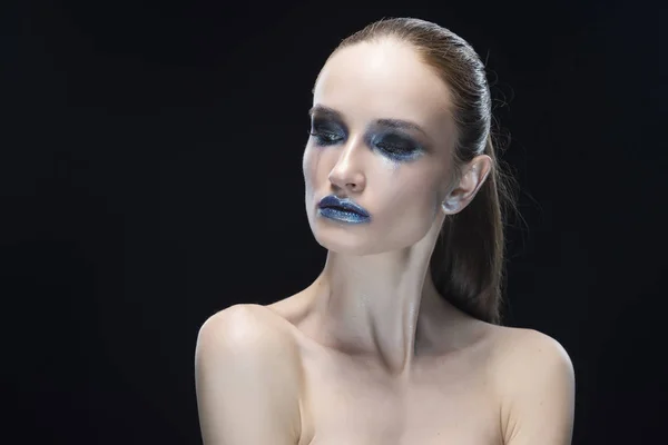 Retrato da jovem com lábios azuis e vanguarda brilho azul make-up isolado em um fundo preto — Fotografia de Stock