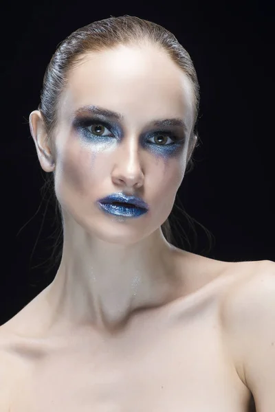 Portrait of the young woman with blue lips and vanguard shine blue make-up isolated on a black background — Stock Photo, Image