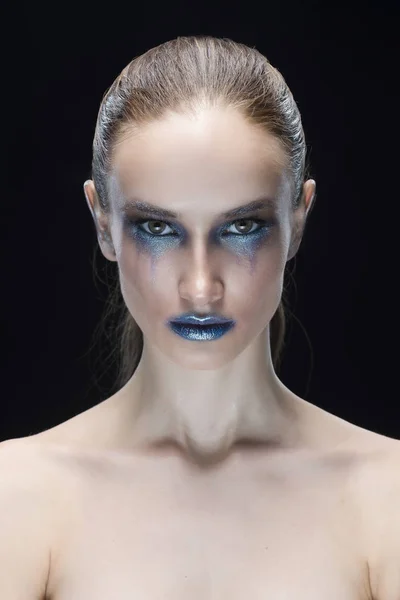 Ritratto della giovane donna con labbra blu e avanguardia brillare blu make-up isolato su uno sfondo nero — Foto Stock