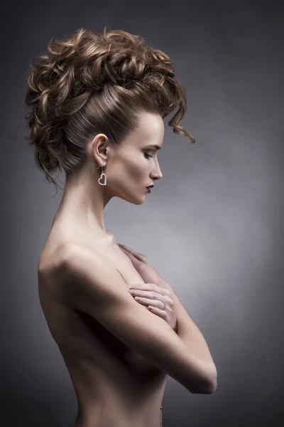 Jovem mulher com vanguarda penteado beleza lado estúdio retrato no fundo cinza — Fotografia de Stock