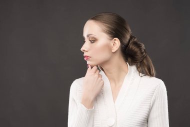 güzel kız gri bir arka plan üzerinde düşünüyor