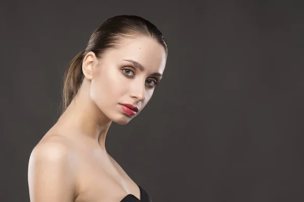 The beautiful girl naked shoulders portrait on a gray background — Stock Photo, Image