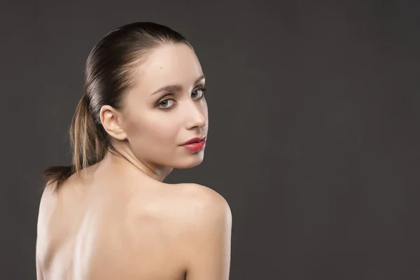 The beautiful girl naked shoulders portrait on a gray background — Stock Photo, Image