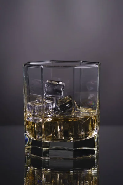 Glas whisky med is på en grå bakgrund — Stockfoto