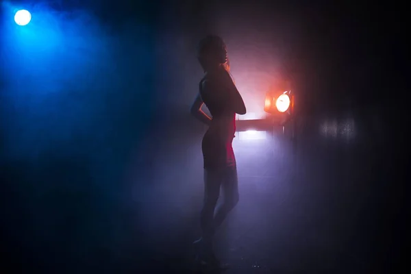 Van het meisje silhouet in mist tegen de achtergrond van lichtbronnen — Stockfoto