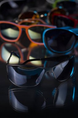 karanlık bir arka plan üzerinde çeşitli güneş gözlüğü