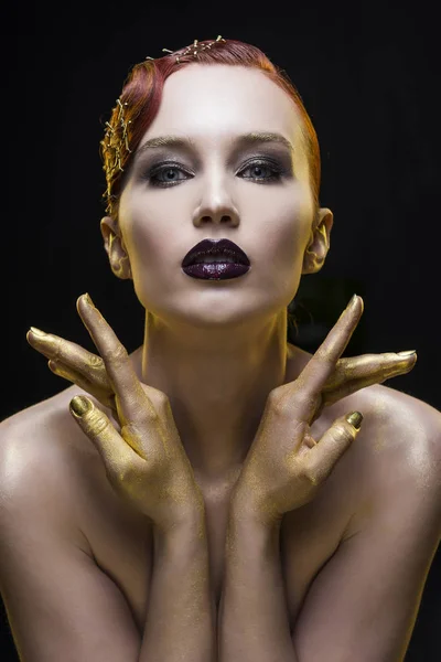 Retrato menina em um fundo preto com os braços tingidos de ouro — Fotografia de Stock