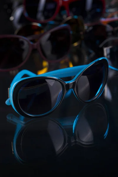 Karanlık bir arka plan üzerinde çeşitli güneş gözlüğü — Stok fotoğraf