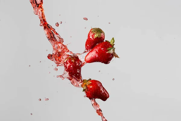 Cuatro fresas y jugo rojo salpicaduras —  Fotos de Stock