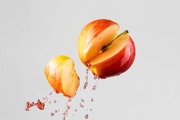 Salpico de maçã e suco vermelho isolado em um fundo cinza — Fotografia de Stock