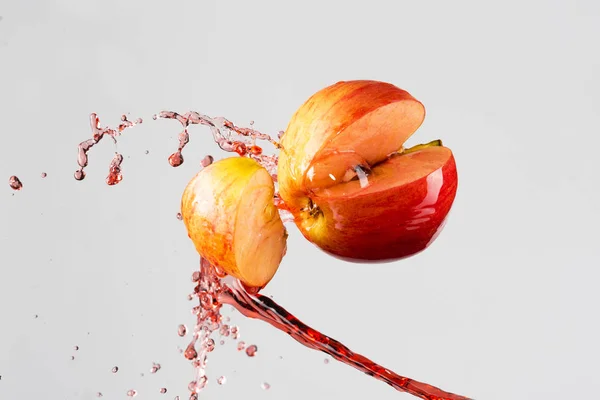 Apple and red juice splash isolated on a gray background — Stock Photo, Image