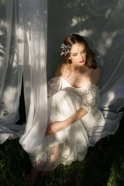 La muchacha hermosa en el vestido de boda sobre la hierba — Foto de Stock