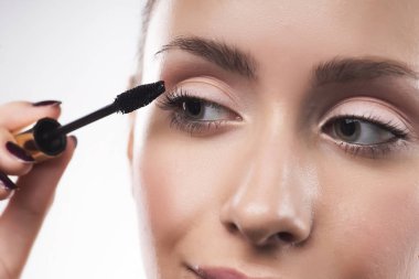 Güzel genç kız ile doğal makyaj maskara eyelas üzerinde koyar.