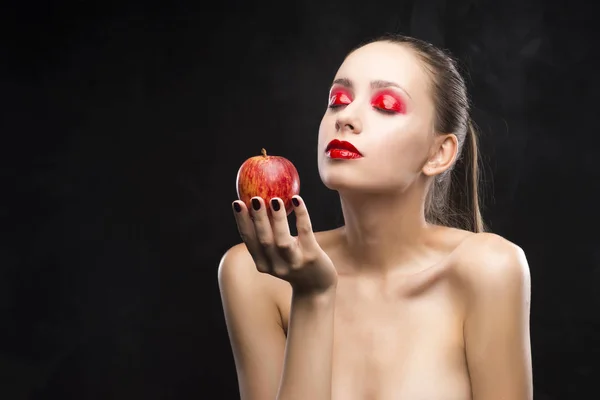 Niña sostiene manzana con la sombra de ojos roja cubierta de brillo —  Fotos de Stock