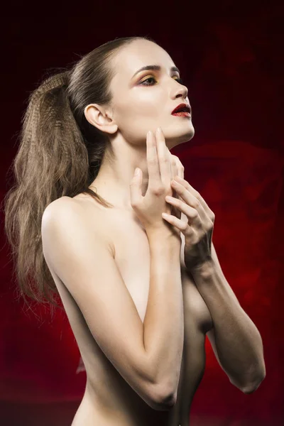 Retrato da menina bonita topless em um fundo vermelho — Fotografia de Stock