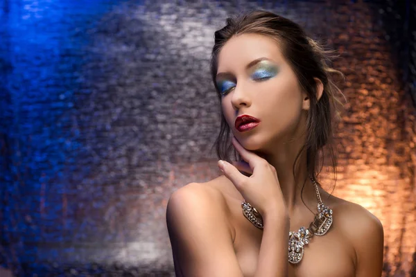 Krásná dívka, která nosí náhrdelník na pozadí barevných fólií — Stock fotografie