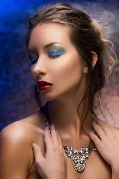 Krásná dívka, která nosí náhrdelník na pozadí barevných fólií — Stock fotografie