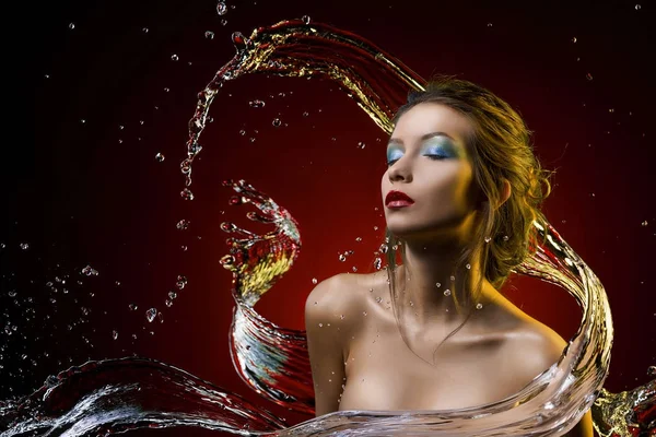 Menina bonita coberta com respingo de água em um fundo vermelho — Fotografia de Stock