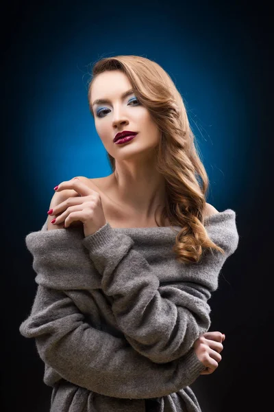 Menina loira bonita vestindo uma camisola cinza com um cabelo elegante — Fotografia de Stock