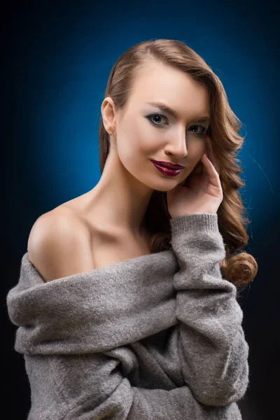 Schöne blonde Mädchen trägt einen grauen Pullover mit eleganten Haaren — Stockfoto