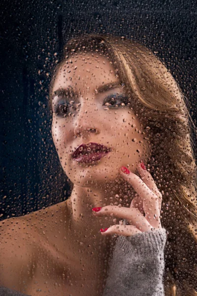 Güzel kız giyiyor ıslak pencere cam dokunur. — Stok fotoğraf