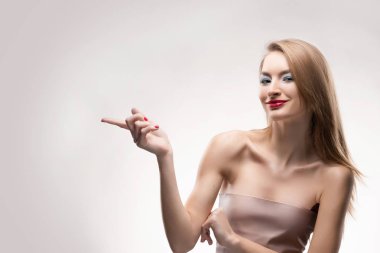 Güzel sarışın kırmızı parmak th için gülümseyen kız Puan dudakları