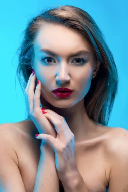 Güzel sarışın kırmızı gülümseyen kız dokunuşlar parmak fa tarafından dudakları.