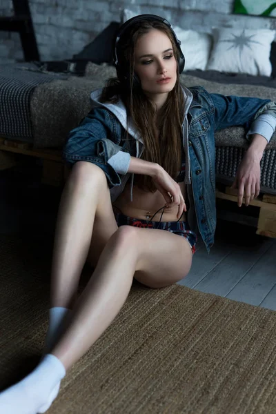 La hermosa chica sentada en un suelo con ropa interior y un je —  Fotos de Stock