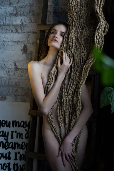 Beautiful naked girl, shyly covering her nakedness with a bunch — Stock Photo, Image