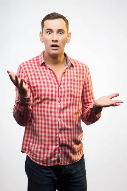 Kırmızı kareli gömlek giyen genç adam ellerini yayılır