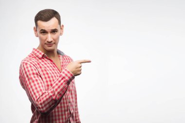 Kırmızı kareli gömlek giyen genç adam için parmağıyla işaret 