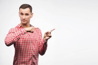 Kırmızı kareli gömlek giyen genç adam için parmağıyla işaret 