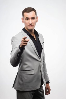Gri takım elbise giymiş bir delikanlı bir işareti gösterir.