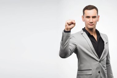 Gri takım elbise giymiş bir delikanlı bir işareti yumruk ortaya çıktı.