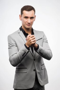 Gri takım elbise giymiş bir delikanlı bir işareti sallamak eller gösterir.