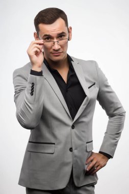 Gri bir takım ve gözlük genç bir adam onun glas düzeltiyor