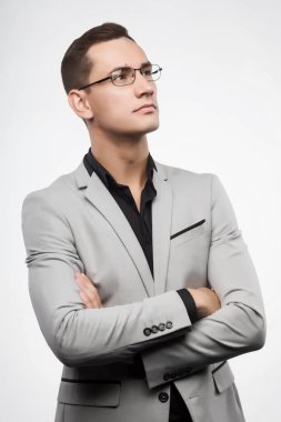 Genç bir adam gri bir takım ve gözlük