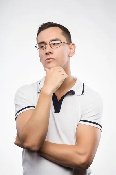 A young positive man in eyeglasses thinks. Emotional, courageous — Stock Photo, Image